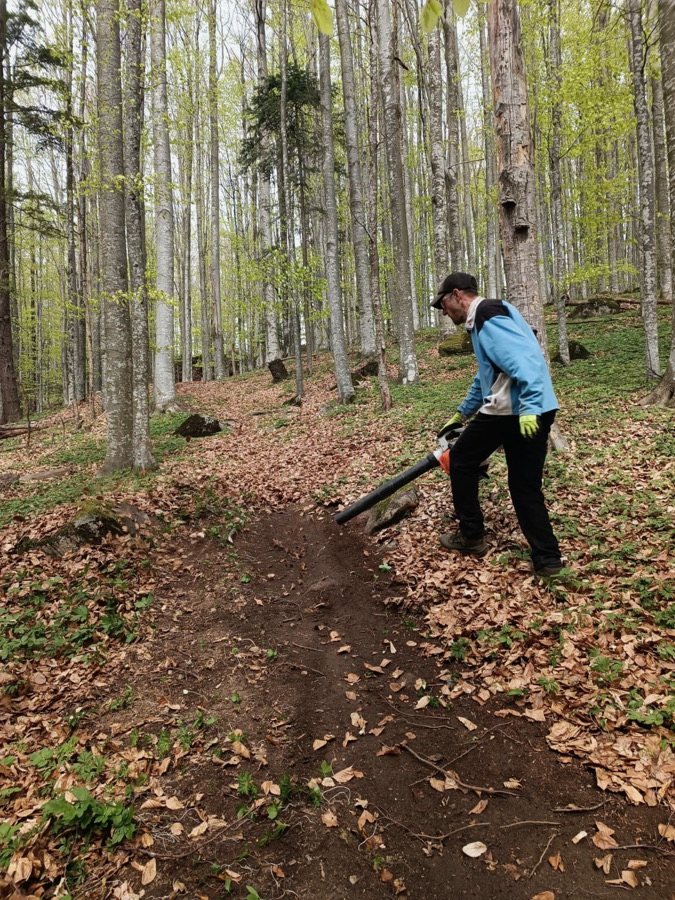 Voluntar curățând traseul cu suflanta